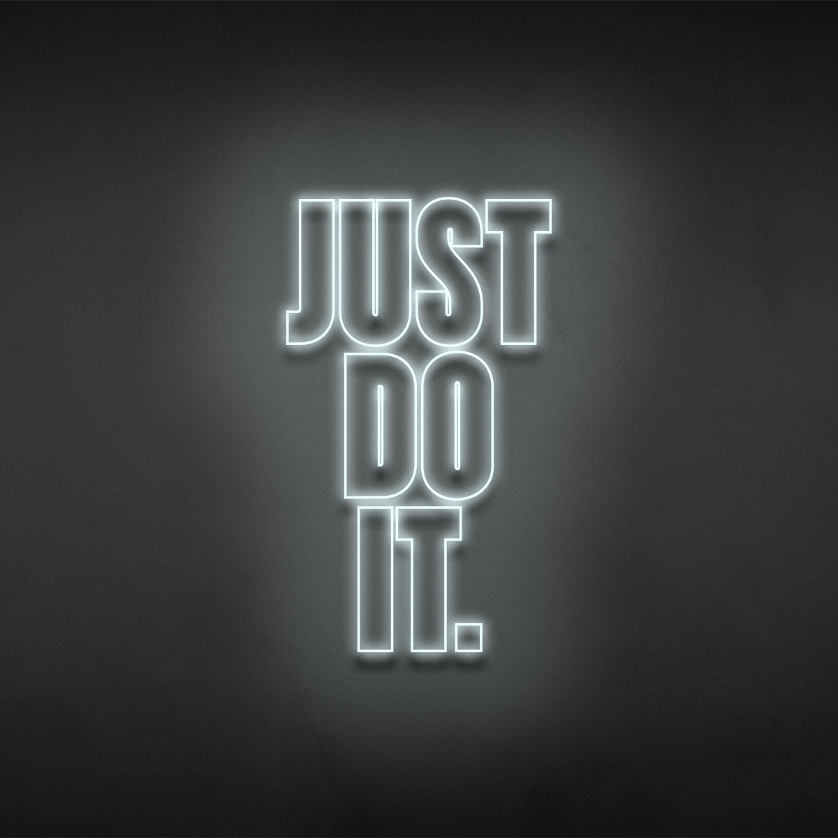 Just Do It statement sign rendered in neon on a dark wall